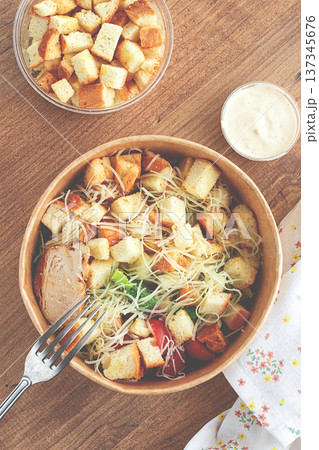 Caesar salad in a paper container, take it on the way, with sauce and croutons, on the table, snack, no people, Caesar salad in a paper container, take it on the way, with sauce and croutons, on the table, snack, no people, 137345676