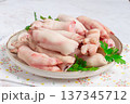 Pork trotters arranged on a plate with fresh parsley on a white background 137345712