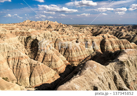 Scenic sunny view of the deeply eroded and colorful layered rock formations from White River Valley Overlook in Badlands National Park, South Dakota, United States. Scenic sunny view of the deeply eroded and colorful layered rock formations from White River Valley Overlook in Badlands National Park, South Dakota, United States. 137345852