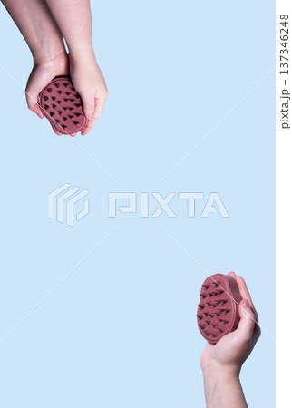 Hair pink scalp massager in woman hand on the pink background isolated. Image with copy space. Mock up for design and banner 137346248