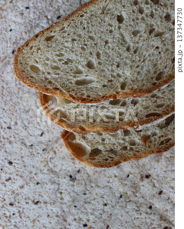 Three slices of yeast-free bread on dietary lavash with sesame seeds texture background 137347730