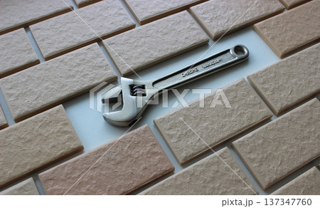 An adjustable spanner in place of a missing tile on a fully tiled surface An adjustable spanner in place of a missing tile on a fully tiled surface 137347760