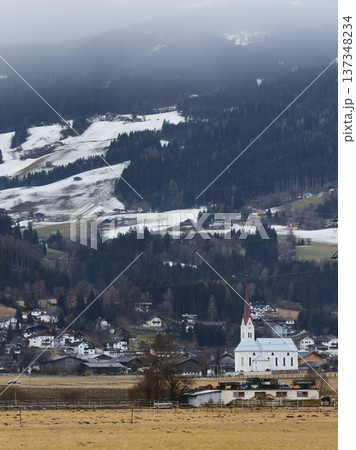 Idyllic Rural Community Situated Beside Majestic Snowy Summits And Lush Fields 137348234