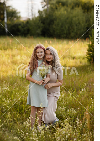 Radiant Outdoor Scene Showing Maternal Love With Wildflowers And Joyful Expressions 137348452