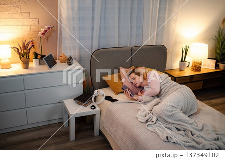 Woman experiencing insomnia doomscrolling on phone in bed 137349102