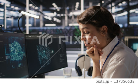 Software developer monitors server clusters performing AI training and inference tasks. IT expert supervising high tech computing systems managing machine learning storage operations, camera A closeup Software developer monitors server clusters performing AI training and inference tasks. IT expert supervising high tech computing systems managing machine learning storage operations, camera A closeup 137350538