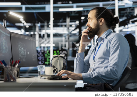 Data center workplace employee using artificial intelligence neural networks tech on computer. Server farm facility system administrator using AI programming language on PC 137350593