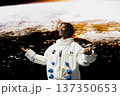 Jolly astronaut in white space suit standing in front of planet glowing horizon with arms open wide. Cheerful cosmonaut mesmerized by outer space, concept of planetary discovery and human wonder 137350653