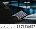 Data center computer scientist using tablet to optimize network infrastructure, planning capacity. Employee managing server room resources with device for improved reliability and uptime 137350657