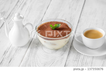 Classic Italian tiramisu dessert in glass bowl with espresso and milk jug 137350876