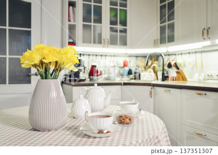 A table set for breakfast with tea and a bouquet of daffodils A table set for breakfast with tea and a bouquet of daffodils 137351307