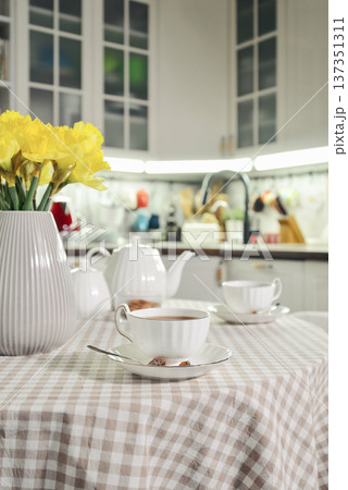 A table set for breakfast with tea and a bouquet of daffodils A table set for breakfast with tea and a bouquet of daffodils 137351311