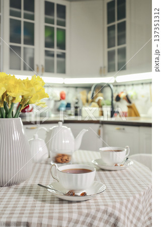 A table set for breakfast with tea and a bouquet of daffodils 137351312