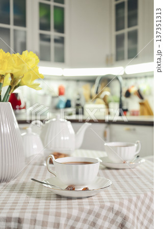 A table set for breakfast with tea and a bouquet of daffodils A table set for breakfast with tea and a bouquet of daffodils 137351313