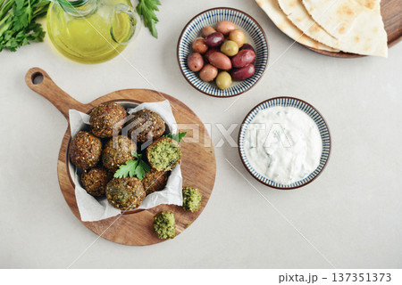 A bowl of crispy golden brown falafel balls with tahini sauce A bowl of crispy golden brown falafel balls with tahini sauce 137351373