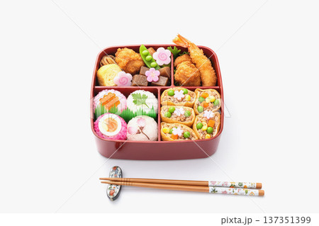 桜の下で楽しむ花見弁当と春の行楽弁当イメージ素材 137351399