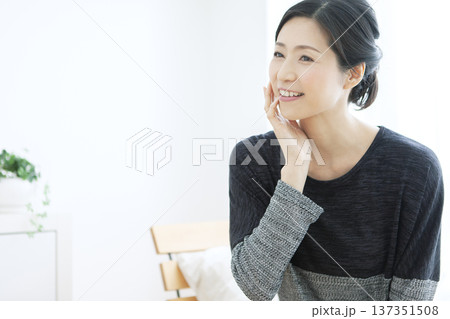 顔に手をあてる中年女性 顔に手をあてる中年女性 137351508