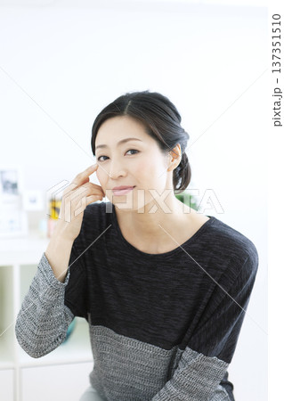 顔に手をあてる中年女性 顔に手をあてる中年女性 137351510