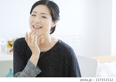 顔に手をあてる中年女性 顔に手をあてる中年女性 137351512