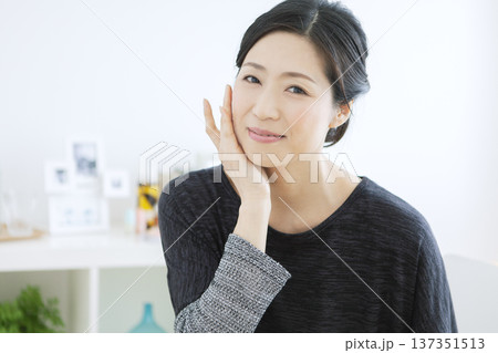 顔に手をあてる中年女性 顔に手をあてる中年女性 137351513