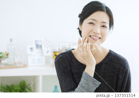 顔に手をあてる中年女性 顔に手をあてる中年女性 137351514
