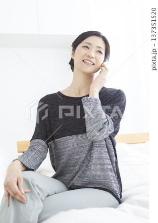 スマートフォンで通話する中年女性 スマートフォンで通話する中年女性 137351520