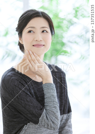 顔に手をあてる中年女性 137351535