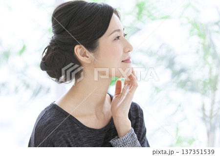 顔に手をあてる中年女性 顔に手をあてる中年女性 137351539