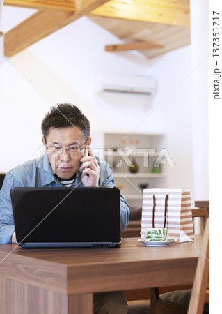 ノートパソコンを操作する中年男性 137351717