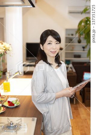 タブレットPCを持った中年女性 タブレットPCを持った中年女性 137351725