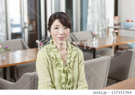 カフェにカウンターに座る中年女性 137351764
