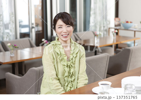 カフェにカウンターに座る中年女性 137351765