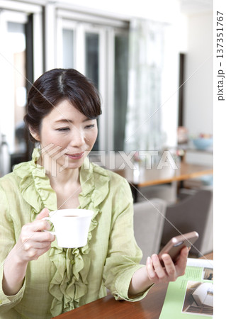 カフェにカウンターに座る中年女性 カフェにカウンターに座る中年女性 137351767