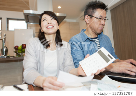 家計簿を作成する中年夫婦 家計簿を作成する中年夫婦 137351797
