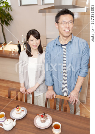 テーブルの前に立つ中年夫婦 テーブルの前に立つ中年夫婦 137351805
