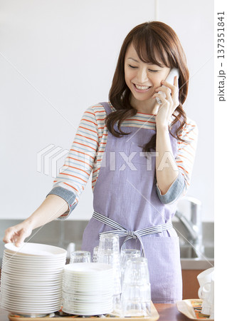電話をかけるカフェスタッフ 137351841