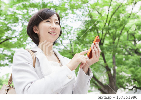 携帯電話を操作するキャリアウーマン 137351990