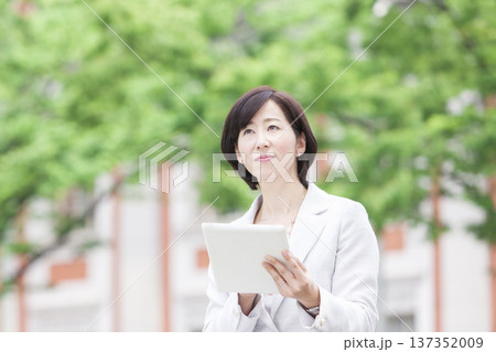 タブレットを操作するキャリアウーマン 137352009