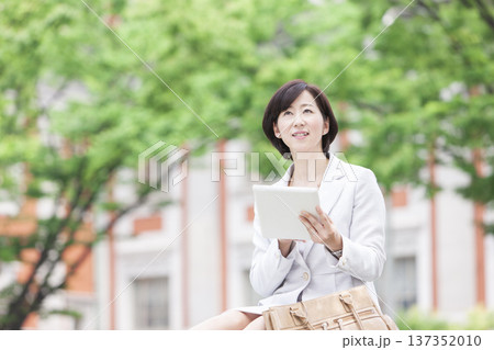 タブレットを操作するキャリアウーマン 137352010