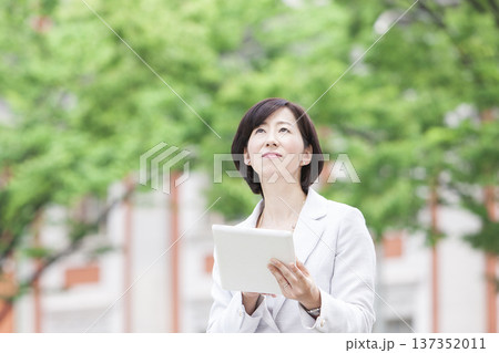 タブレットを操作するキャリアウーマン 137352011