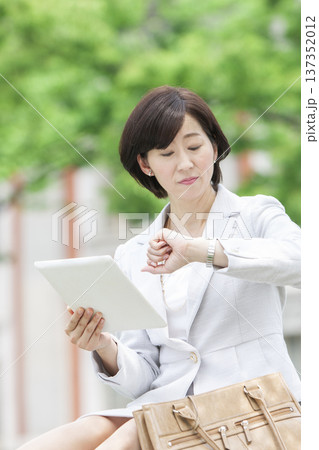 腕時計を見るキャリアウーマン 137352012