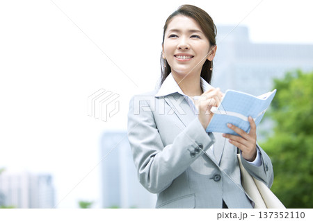 手帳を持ったビジネスウーマン 手帳を持ったビジネスウーマン 137352110
