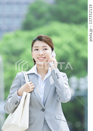 スマートフォンで電話するビジネスウーマン スマートフォンで電話するビジネスウーマン 137352119