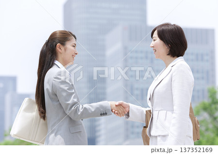 オフィス街で握手をする２人のビジネスウーマン 137352169