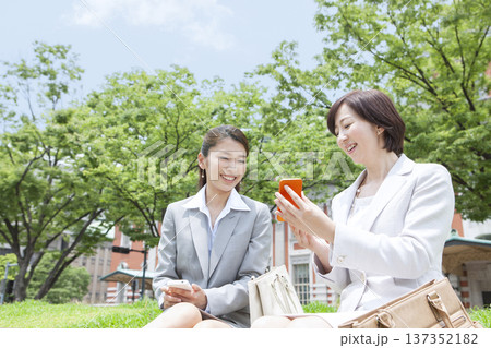 スマートフォンを見る2人のビジネスウーマン スマートフォンを見る2人のビジネスウーマン 137352182
