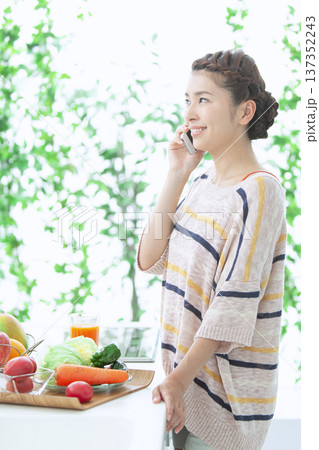 キッチンで電話をする女性 137352243