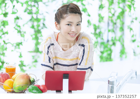 キッチンでタブレットを操作する女性 137352257