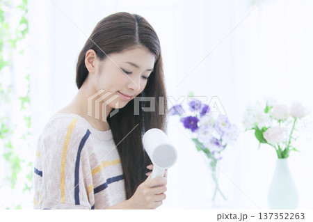ドライヤーで髪を乾かす女性 ドライヤーで髪を乾かす女性 137352263