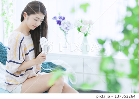 ドライヤーで髪を乾かす女性 137352264