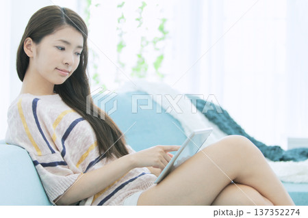 ソファでタブレットを操作する女性 ソファでタブレットを操作する女性 137352274